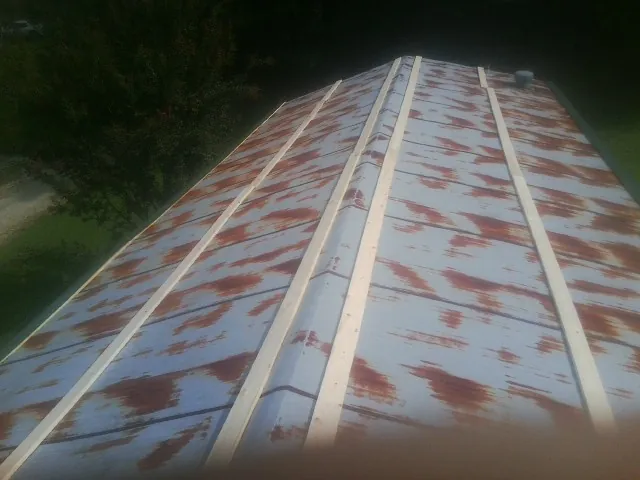 Rusted metal roof panels with new wood purlins before replacement — Storm Damage Roof Repair in Elon by Roofing Brothers