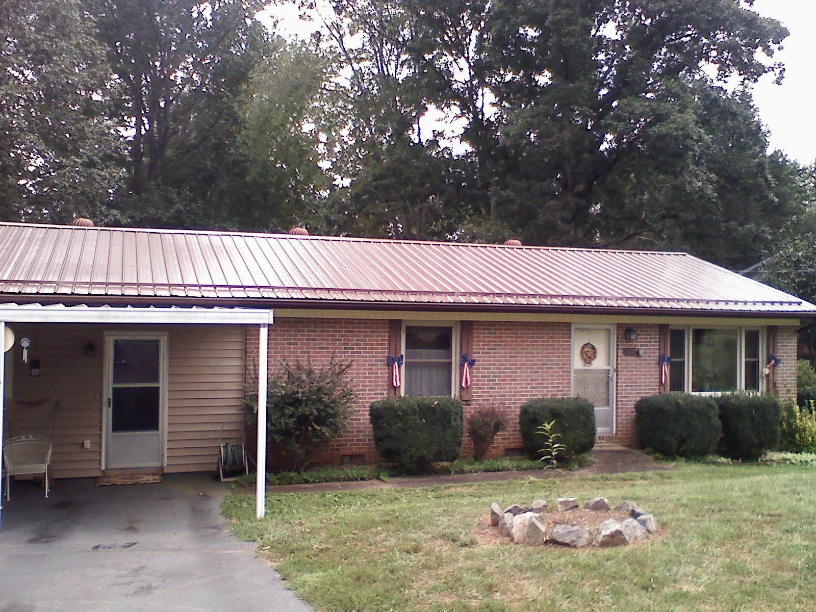 Bronze metal roof and carport on a brick ranch home — Roof Repair work by our crew in Elon