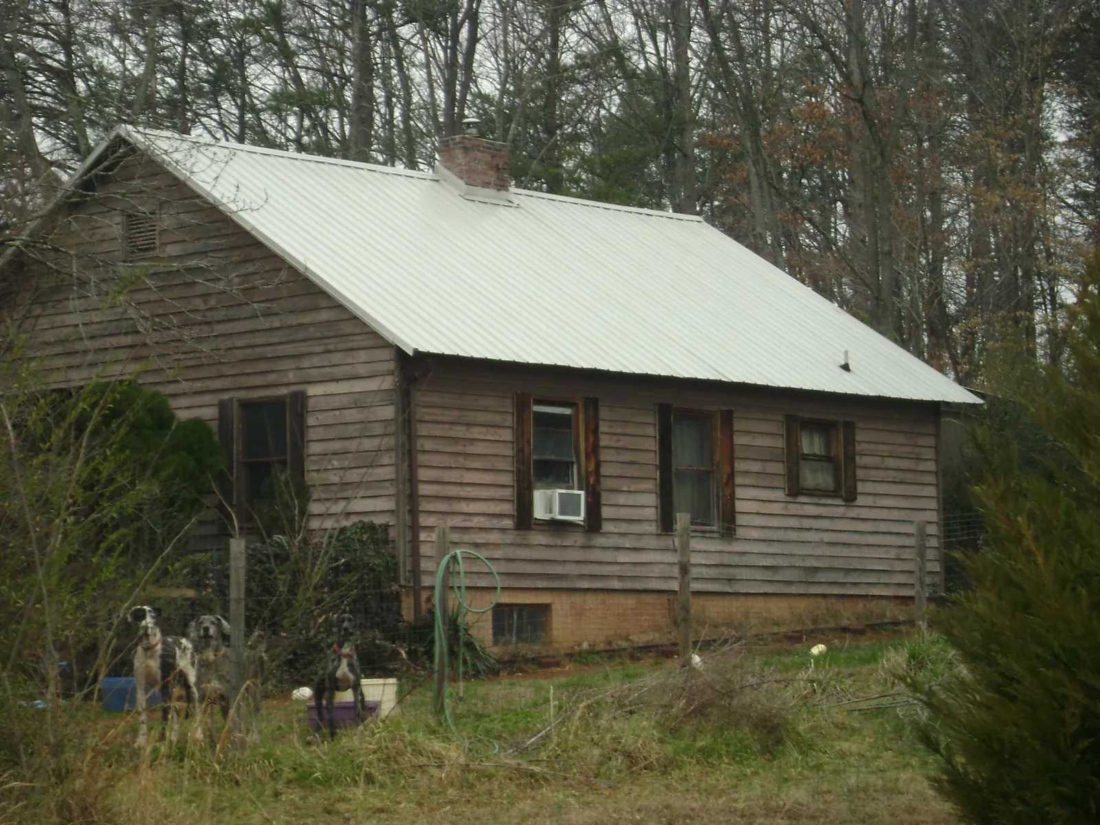 White metal roof on an old wood sided farmhouse, from a Metal Roof Installation job in Elon